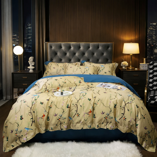 Bedroom with a bed featuring a floral comforter and blue blanket, nightstands with lamps, and cityscape view.