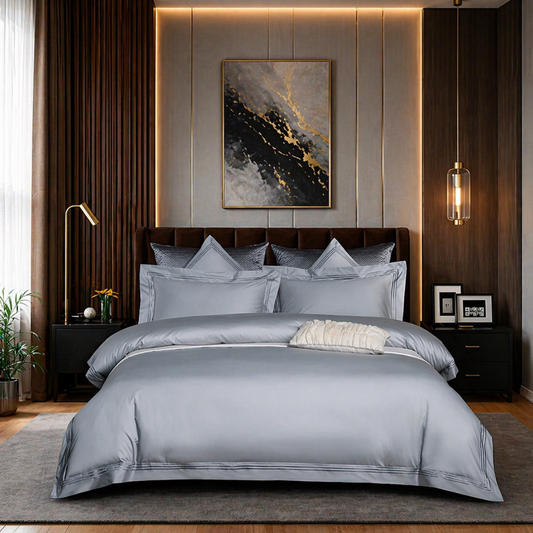 Neatly made bed with gray bedding in a modern bedroom setting.