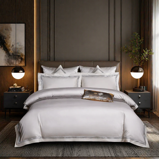 Neatly made bed with gray bedding in a modern bedroom setting.
